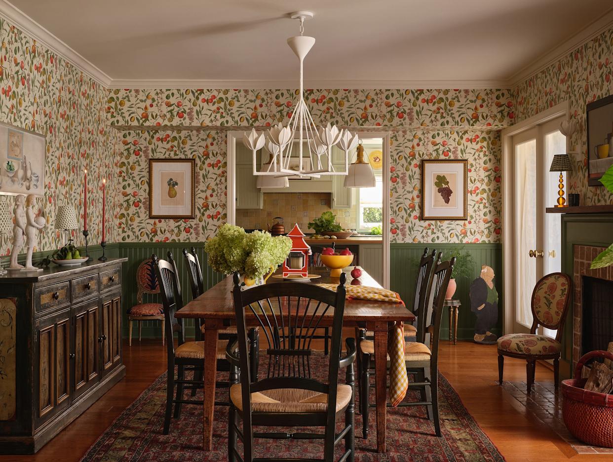 Dining area featuring decorative floral wallpaper and a wooden table.