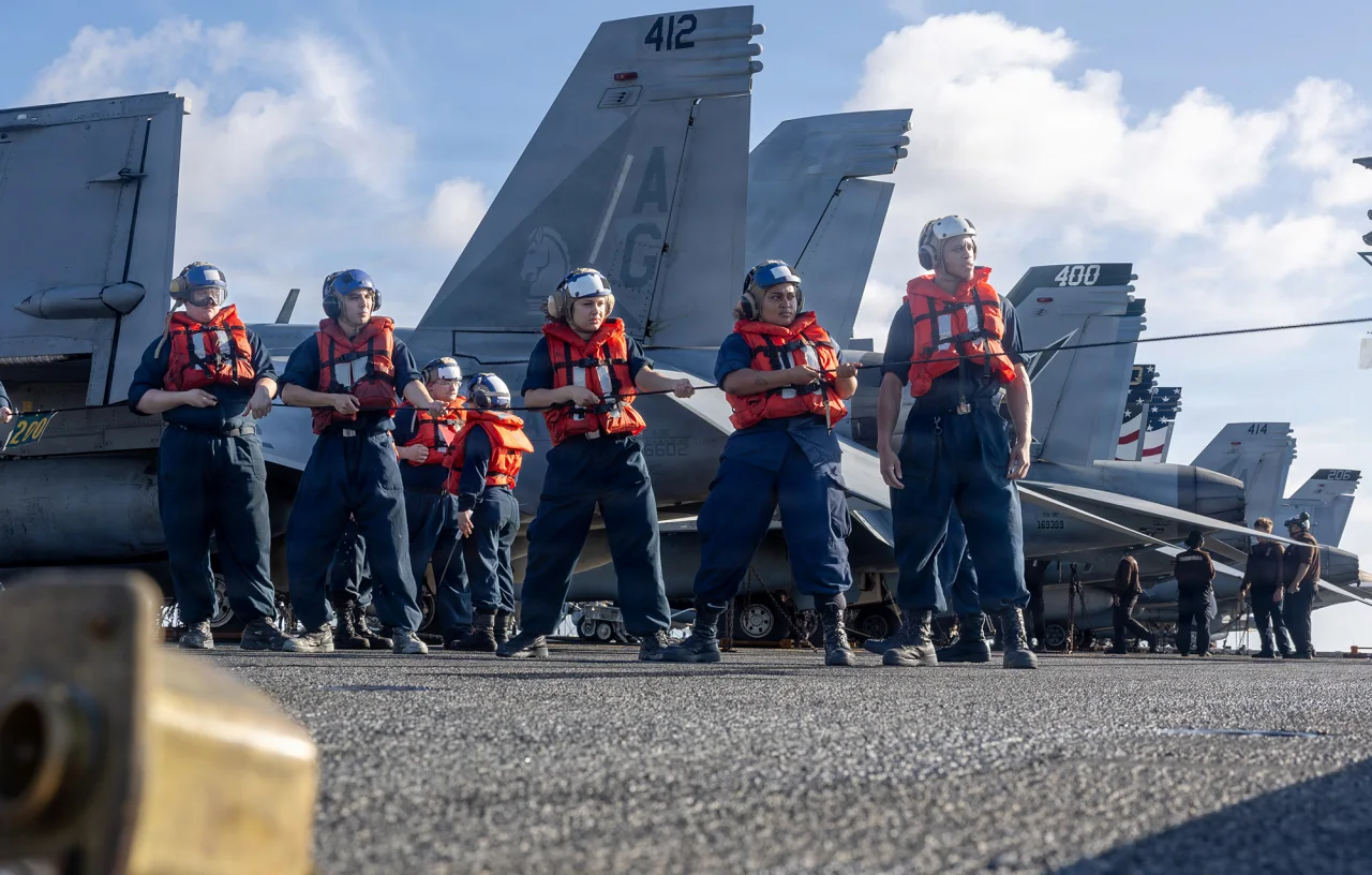 Sailors handle line during a replenishment-at-sea with Supply-class fast combat support ship USNS Arctic on the flight deck of Nimitz-class aircraft carrier USS George H.W. Bush in the Indian Ocean, on April 19.