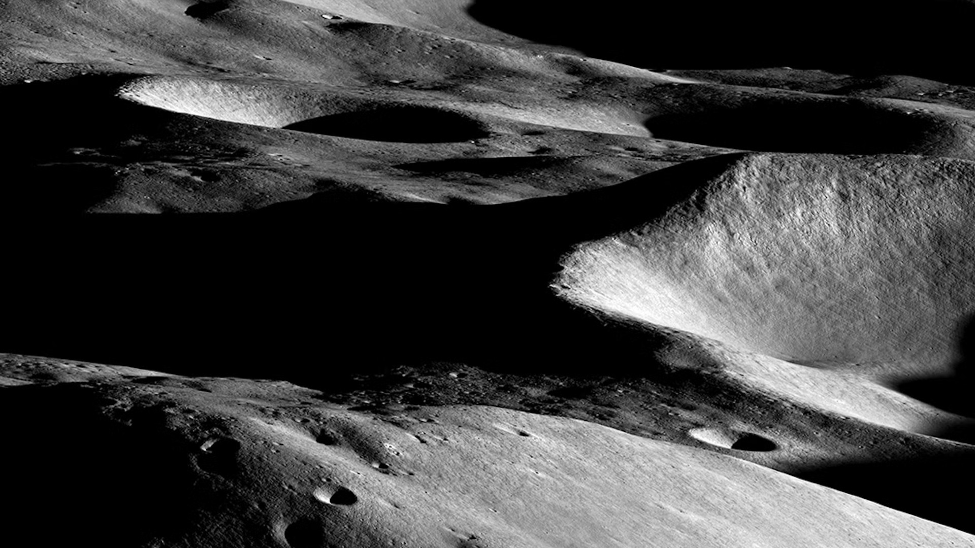 deep craters, some in shadow, on the grey surface of the moon