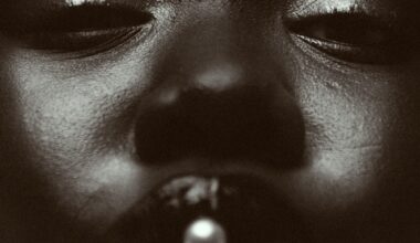 a black and white photo by Austn Fischer of a woman with a pearl in her mouth
