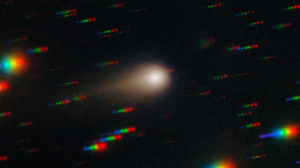 Comet 3I/ATLAS streaks across a dense star field, with background stars appearing as colorful streaks due to the comet being fixed in the center of the telescope's field of view during exposure.