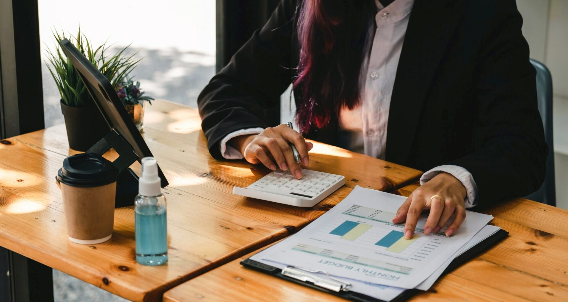 Person making calculations with calculator and data sheets.