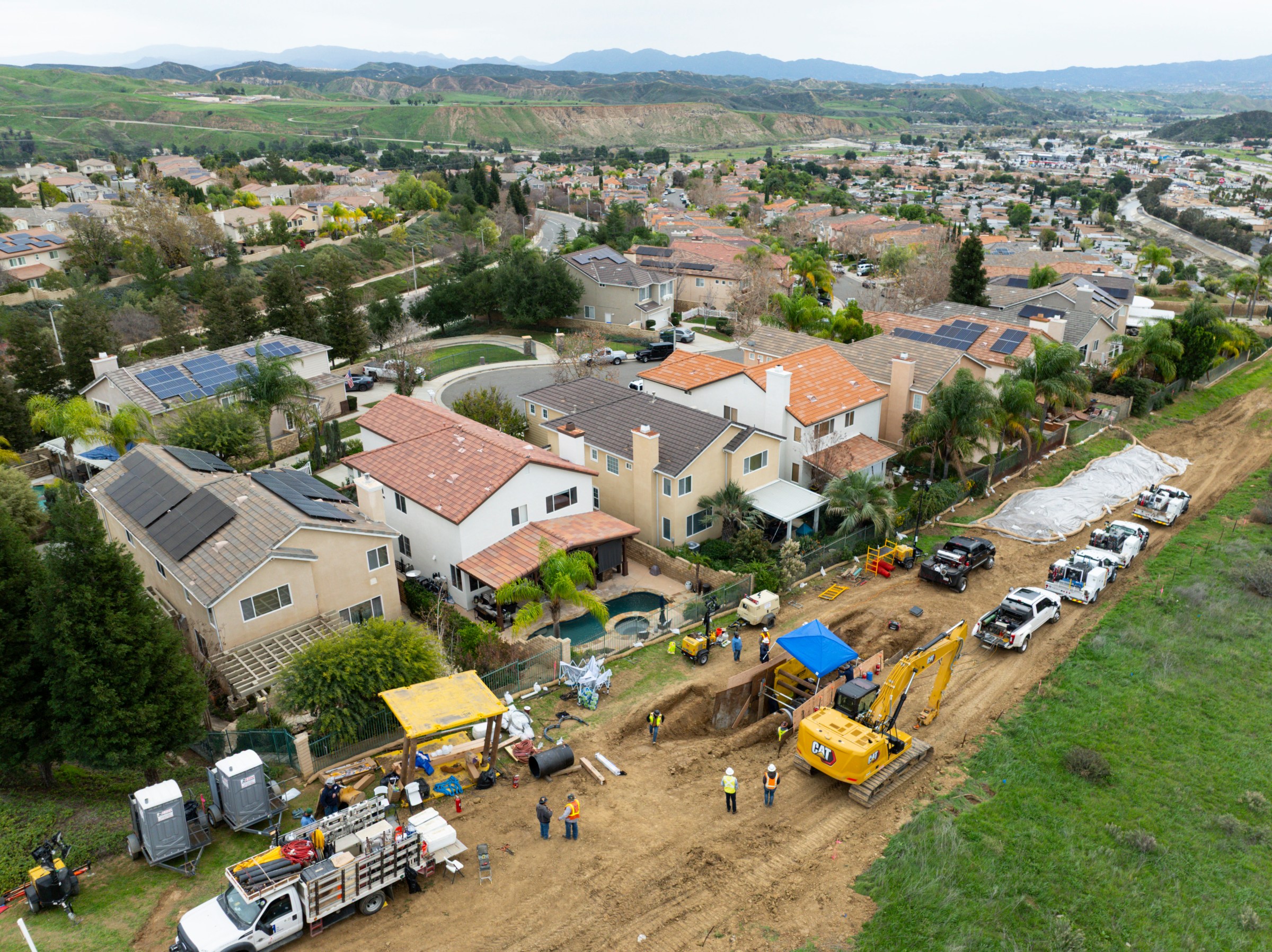 Aerial shot of a densely populated California neighborhood, where a gas crew is repairing a natural gas line.