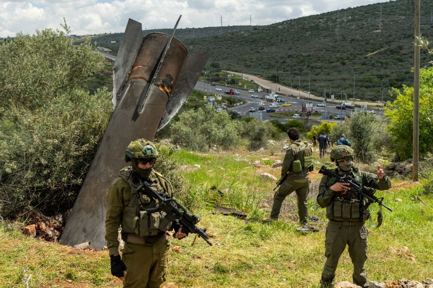 Israeli soldiers stand near an Iranian missile embedded in the ground in the Palestinian village of Hares, in the West Bank, on March 24, 2026.