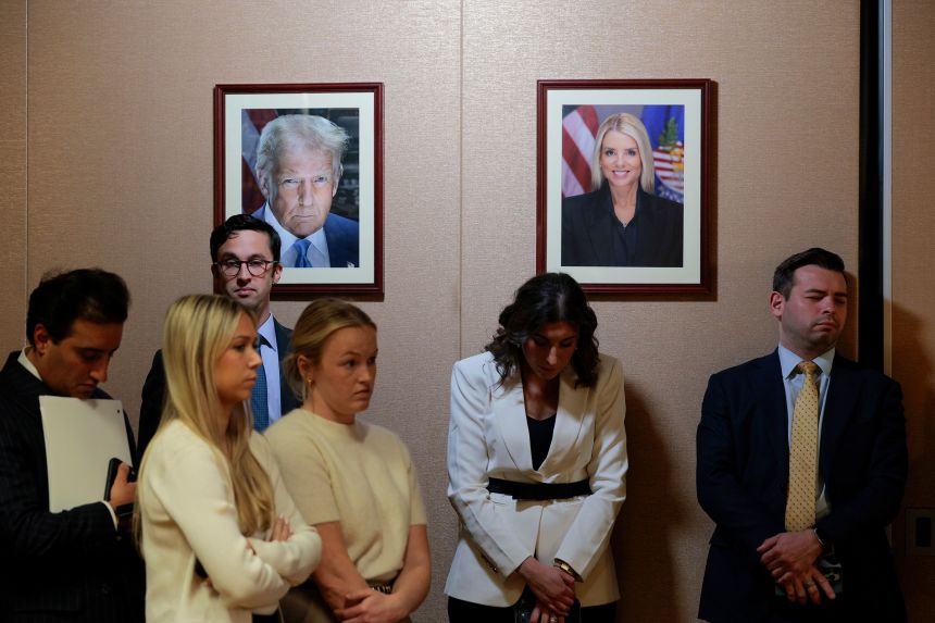 Portraits of President Donald Trump and former US Attorney General Pam Bondi are seen during a news conference with acting US Attorney General Todd Blanche, at the Department of Justice building on April 07, 2026.