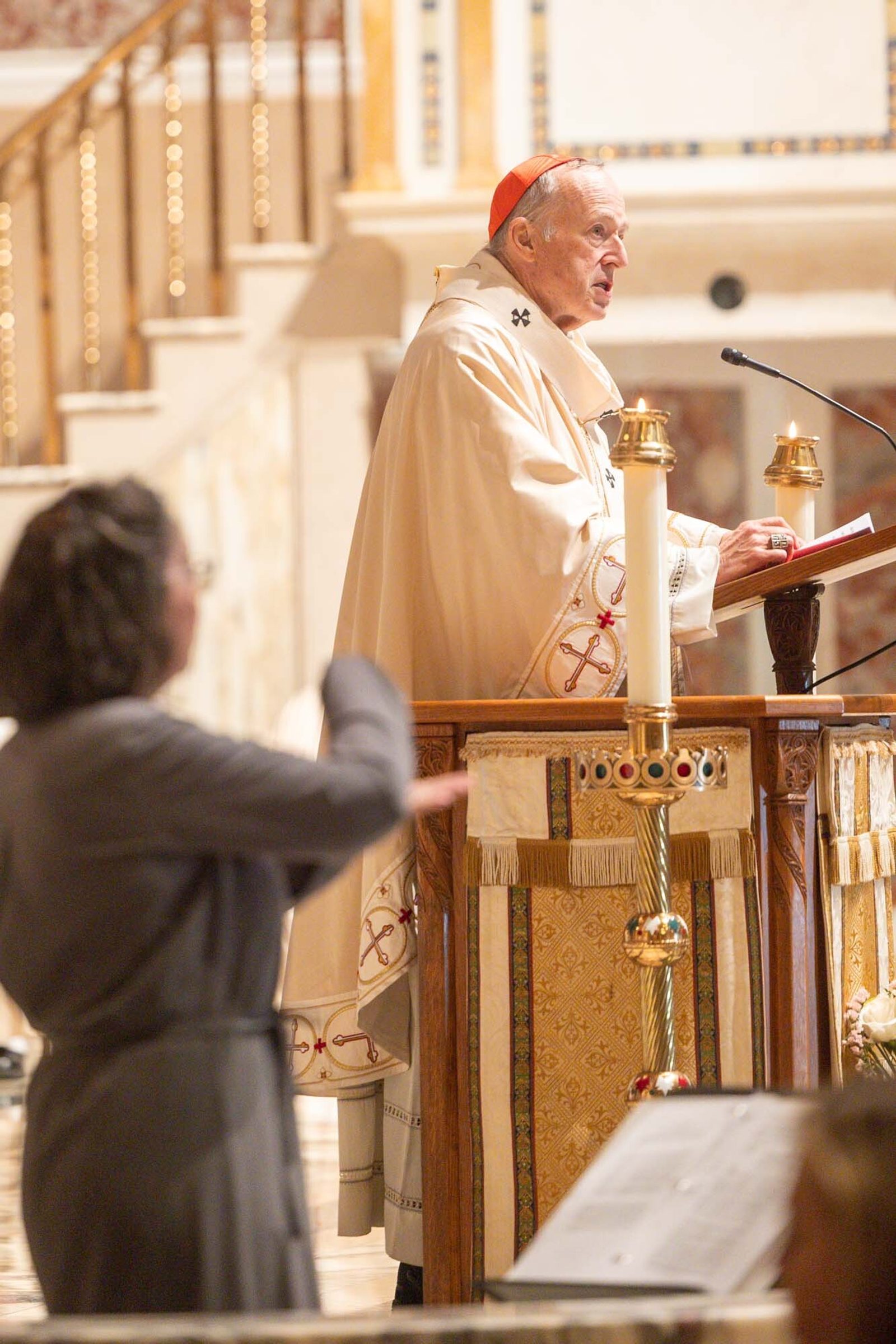 Cardinal Robert W. McElroy, the archbishop of Washington, gives the homily during a Vigil Mass for Peace on April 11, 2026 at the Cathedral of St. Matthew the Apostle, joining Pope Leo XIV and Catholic parishes throughout the world in praying for peace that day. Providing Sign Language interpretation at left is Mary O’Meara, the executive director of the Office of Deaf and Disabilities Ministries for the Roman Catholic Archdiocese of Washington. (Catholic Standard photo by Mihoko Owada)