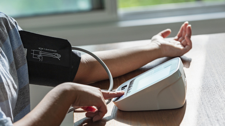 person measuring their blood pressure using a cuff