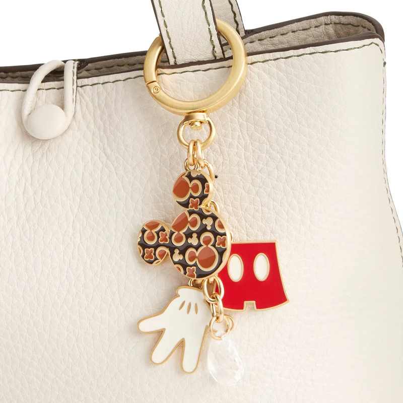 With an overall Mickey Mouse theme, this bag charm has multiple hanging metal charms. One is Mickey's gloved hand, another is his pants, one is a Mickey head icon with miniature Mickey icons inside it and a little crystal charm.