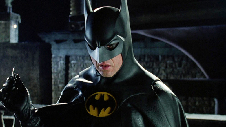 Michael Keaton's Batman looks down as he stands on a rooftop in Batman Returns