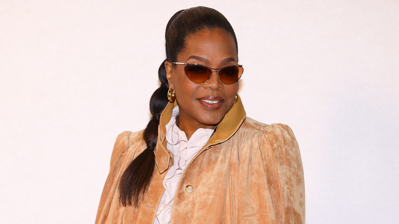Oprah Winfrey who has repeatedly spoken about using GLP-1 medications, posing in a white blouse and brown jacket