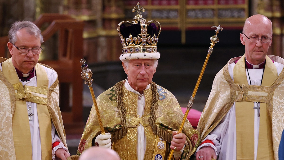King Charles standing in ceremonial attire during his coronation.