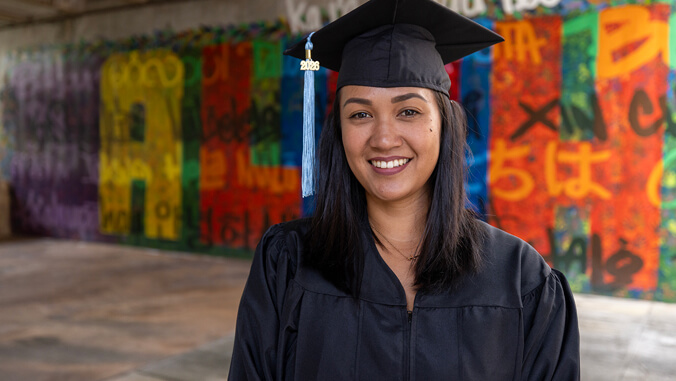 Kikila smiling in her cap and gown