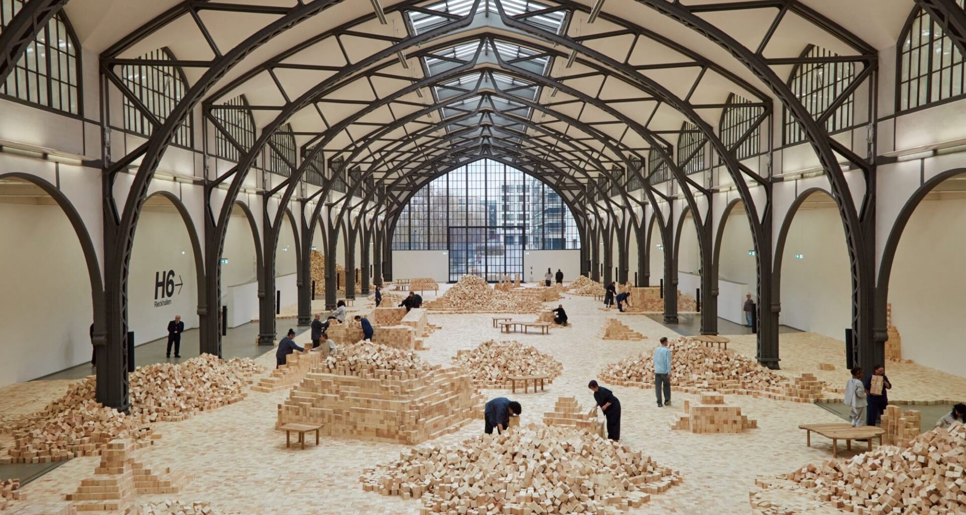 an installation of wooden blocks by Lina Lapelytė in a cavernous building