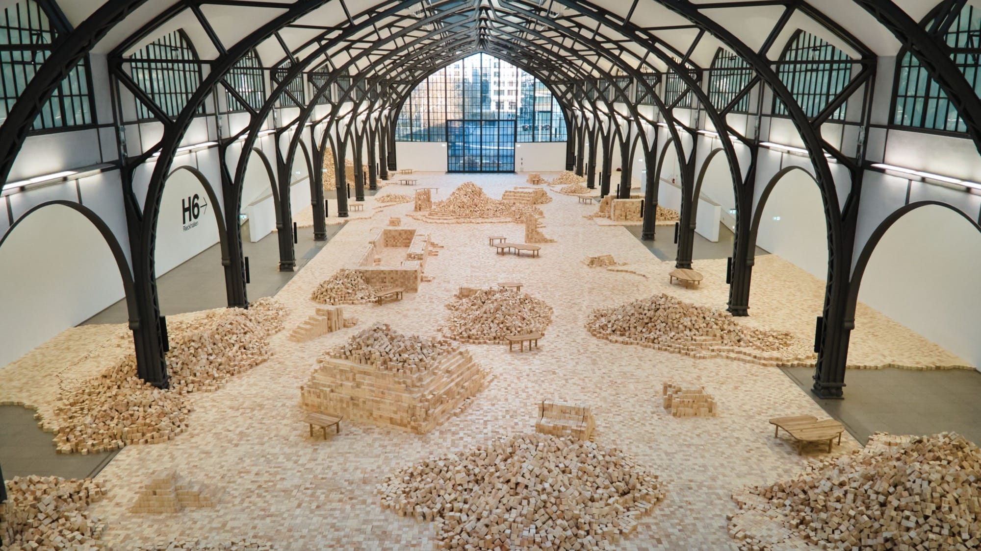 an installation of wooden blocks by Lina Lapelytė in a cavernous building
