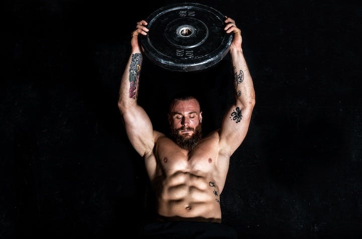 young sweaty fit strong muscular man with big muscles doing hardcore cross abs workout training on the gym floor with weight plate young sweaty fit strong muscular man with big muscles doing hardcore cross abs workout training on the gym floor with weight plate
