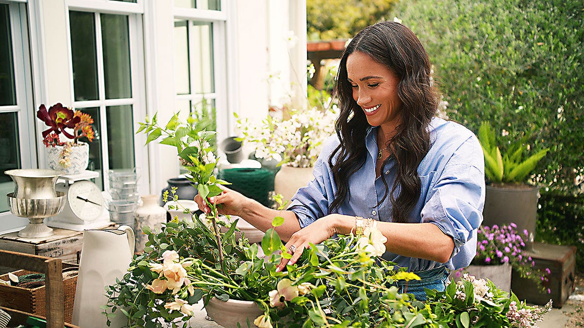 Meghan Markle smiling while gardening in a scene from With Love Meghan on Netflix