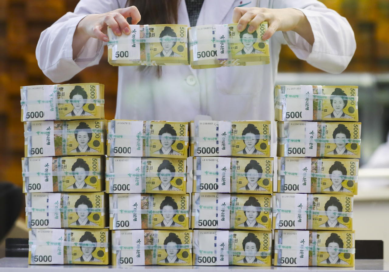 A 2023 file photo shows an employee sorting 50,000 won banknotes at the counterfeit detection center of Hana Bank in central Seoul. (Newsis)