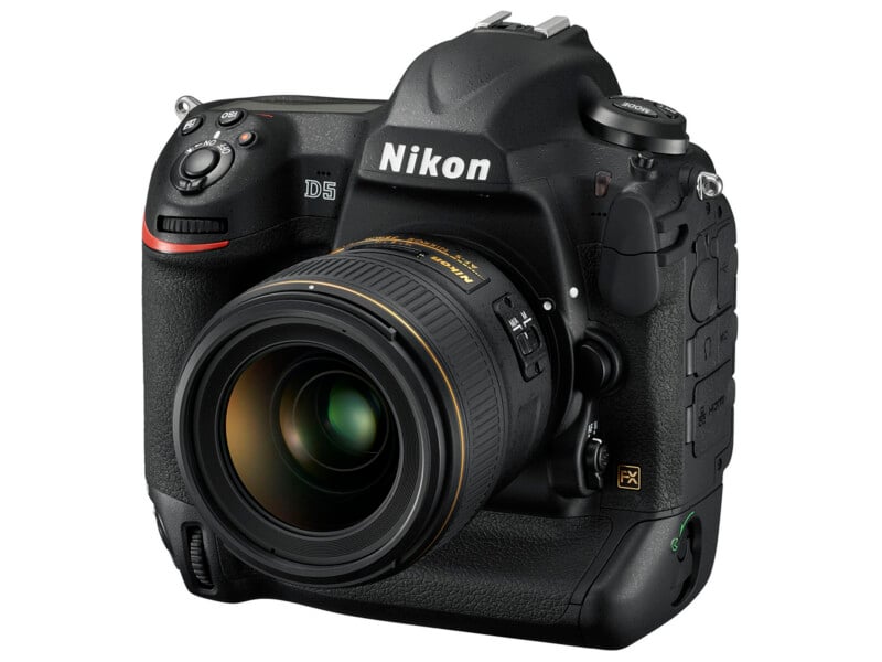 A black Nikon D5 professional DSLR camera with a large lens attached, shown at an angle highlighting the brand logo, lens details, and camera controls.