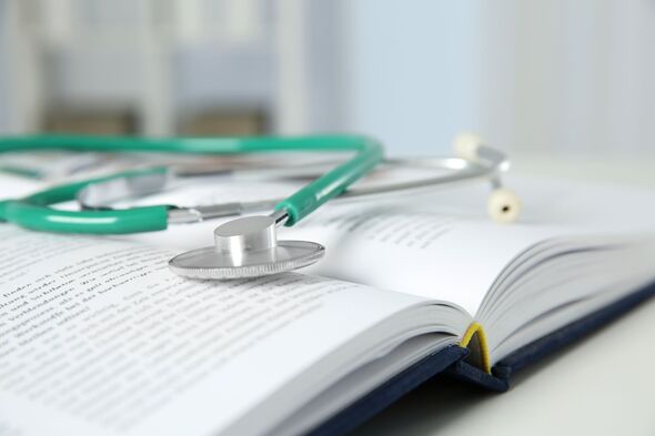One medical stethoscope and book on white table, closeup One medical stethoscope and book on white table, closeup