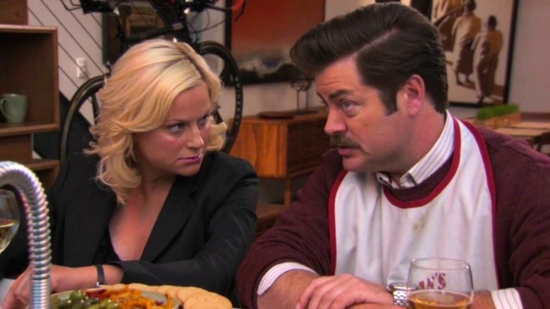 Leslie Knope (Amy Poehler) and Ron Swanson (Nick Offerman) speak over dinner in Parks and Recreation