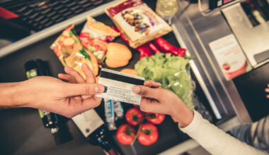 Customer handing over their credit card at the supermarket checkout (Getty Images/GeorgeRudy)