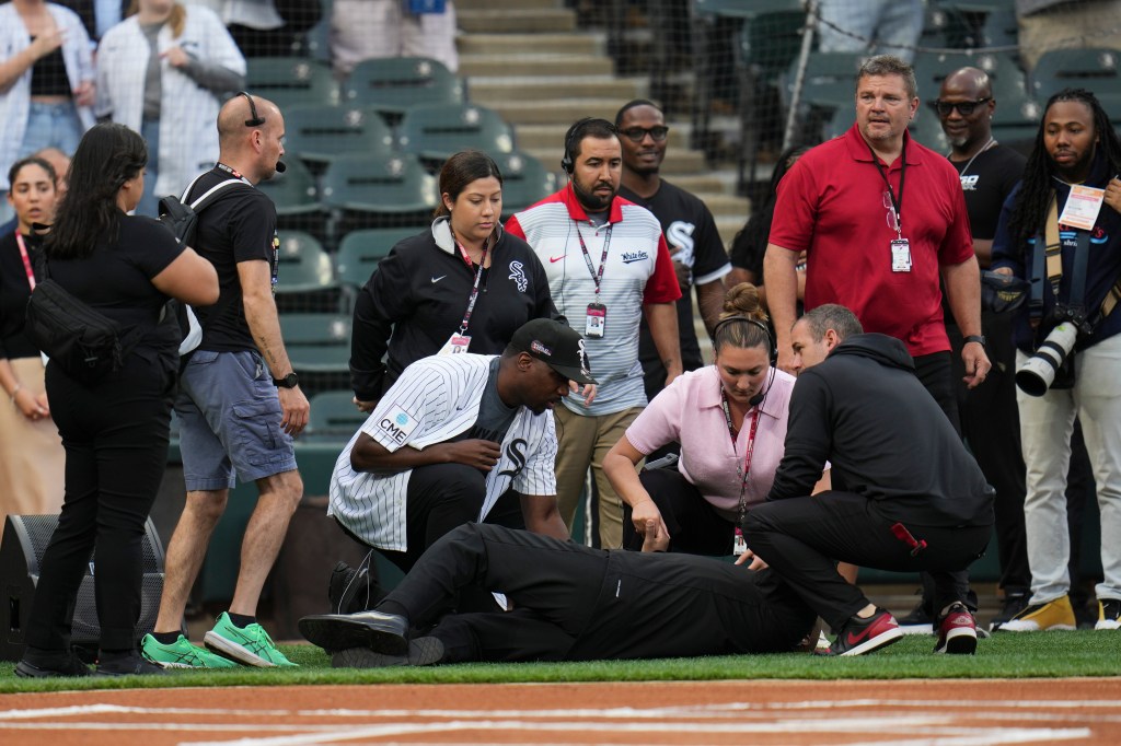 People attending to a man who collapsed during a baseball game.