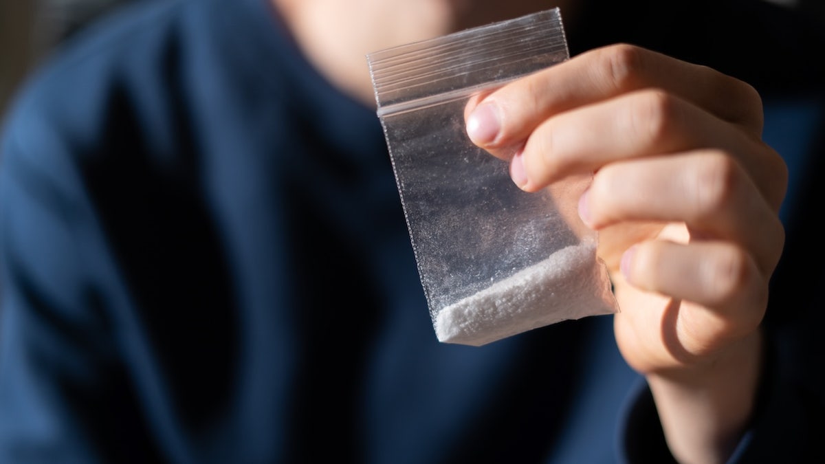 Person holding fentanyl powder in bag
