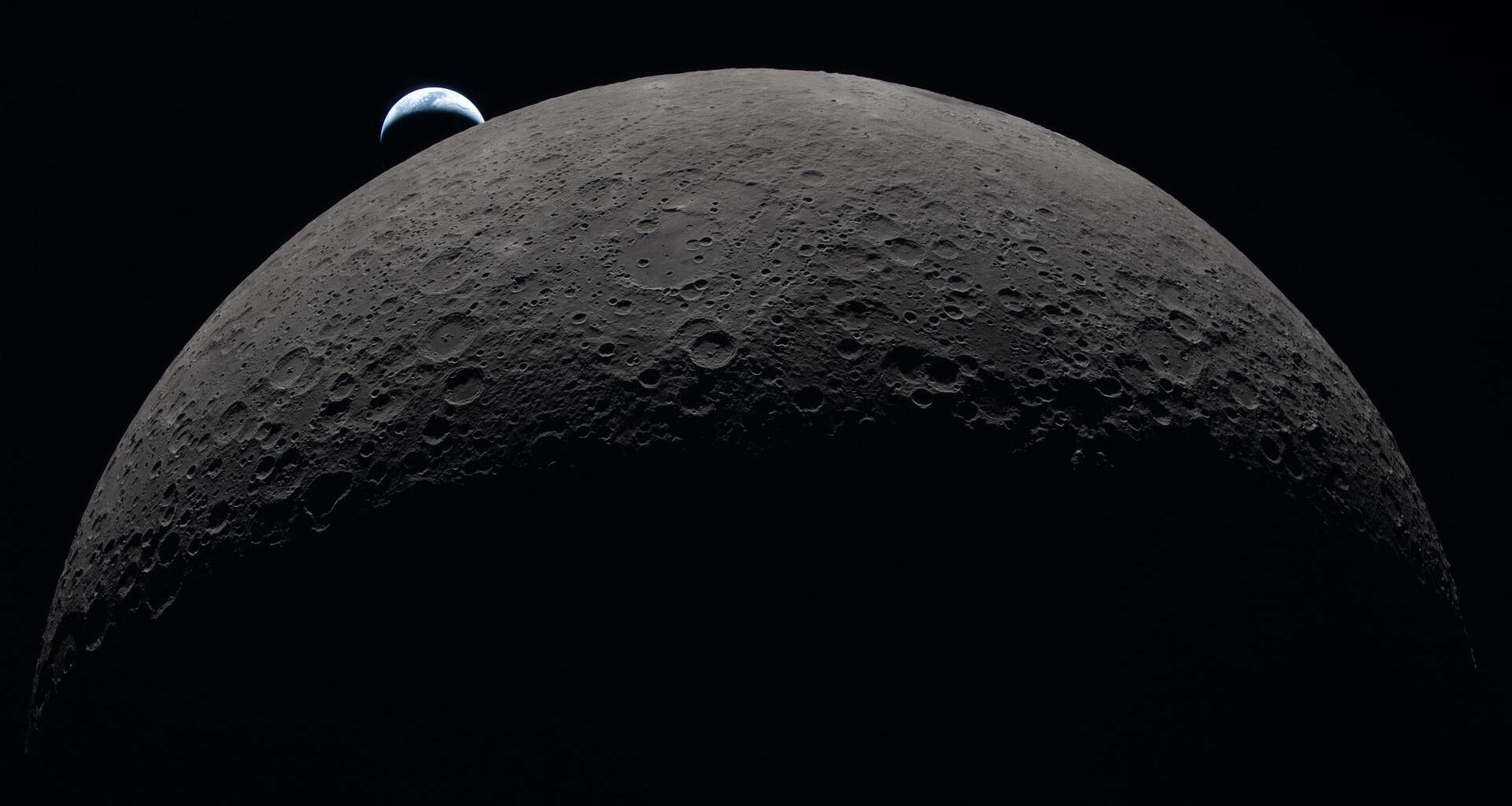 view of the tiny-looking earth above the moon, seen from a spacecraft beyond the moon