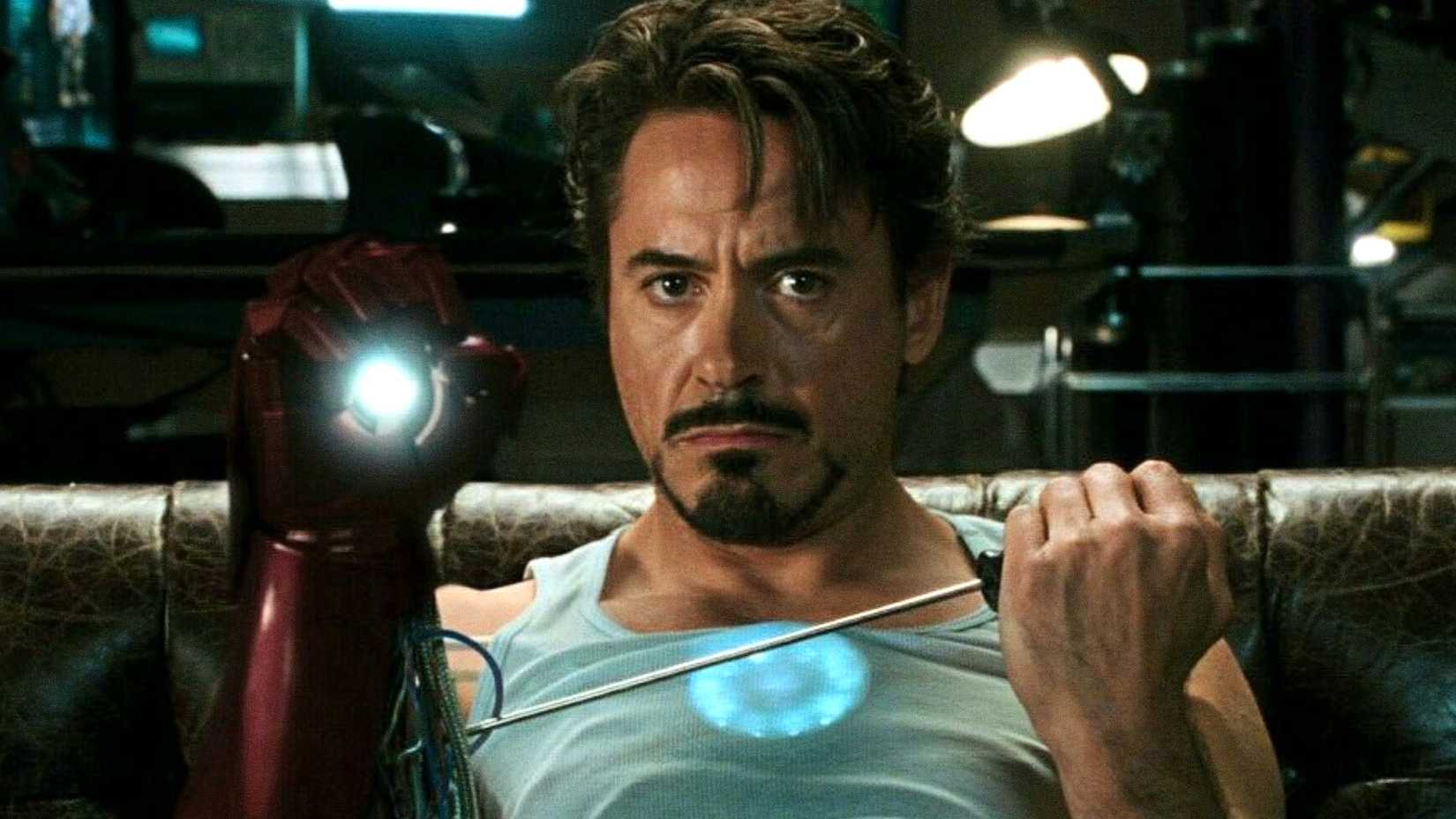 Robert Downey Jr.'s Tony Stark fixes his armor's glove in Iron Man