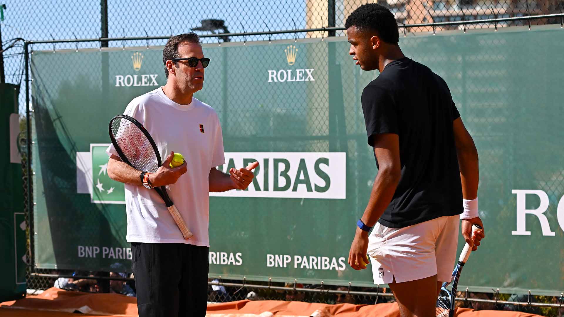 Greg Rusedski and Giovanni Mpetshi Perricard chat during a training session Sunday in Monte-Carlo.