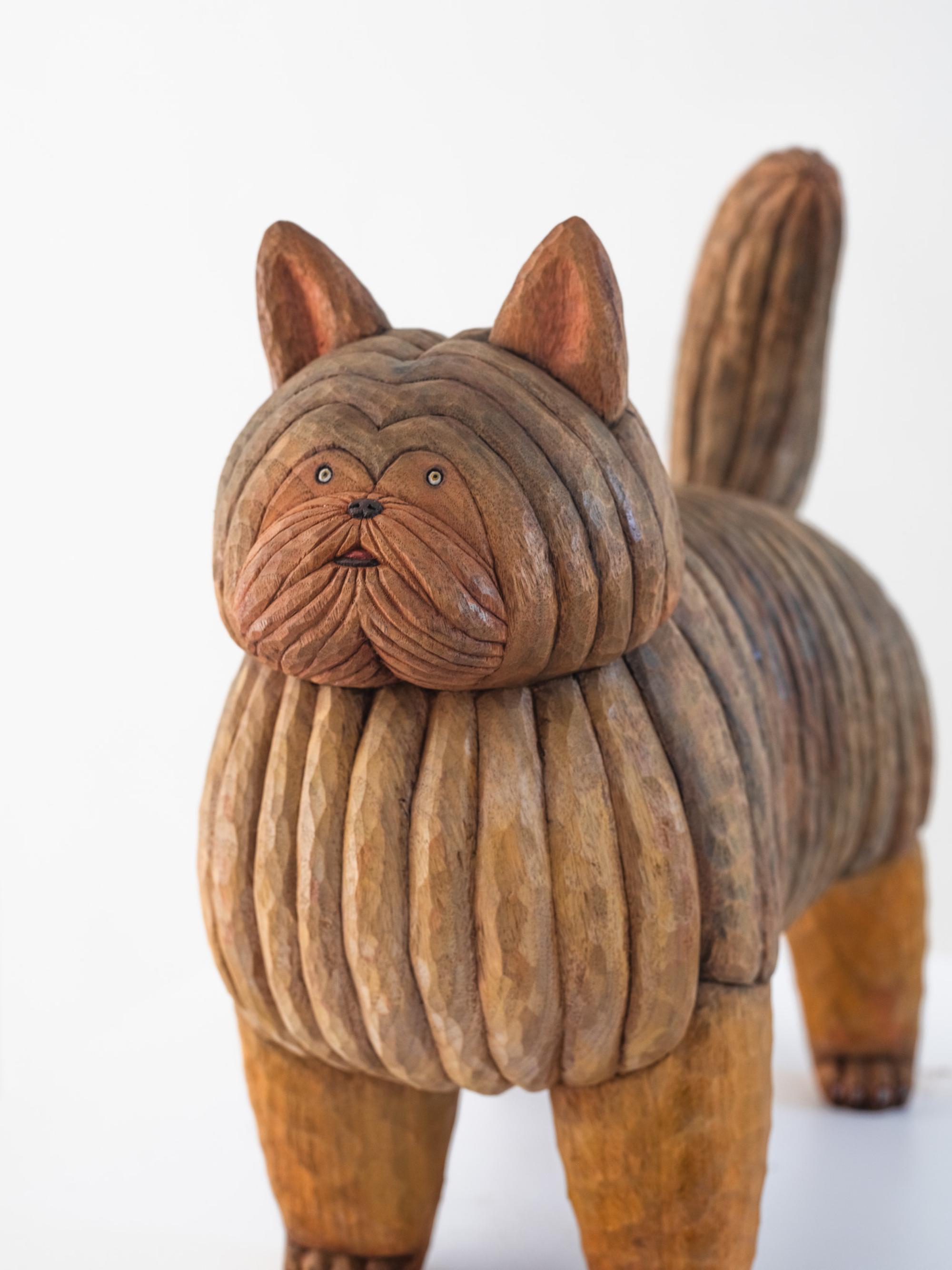a wood-carved yorkie sculpture by Misato Sano