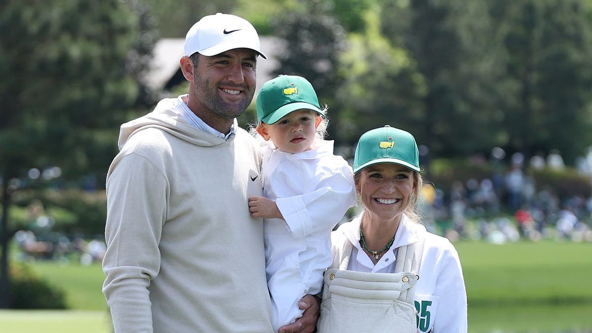 Scottie Scheffler posing with wife Meredith and sons Bennett and Remy on golf course tee.