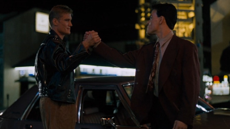 Chris Kenner (Dolph Lundgren) and Johnny Murata (Brandon Lee) clasping hands in 