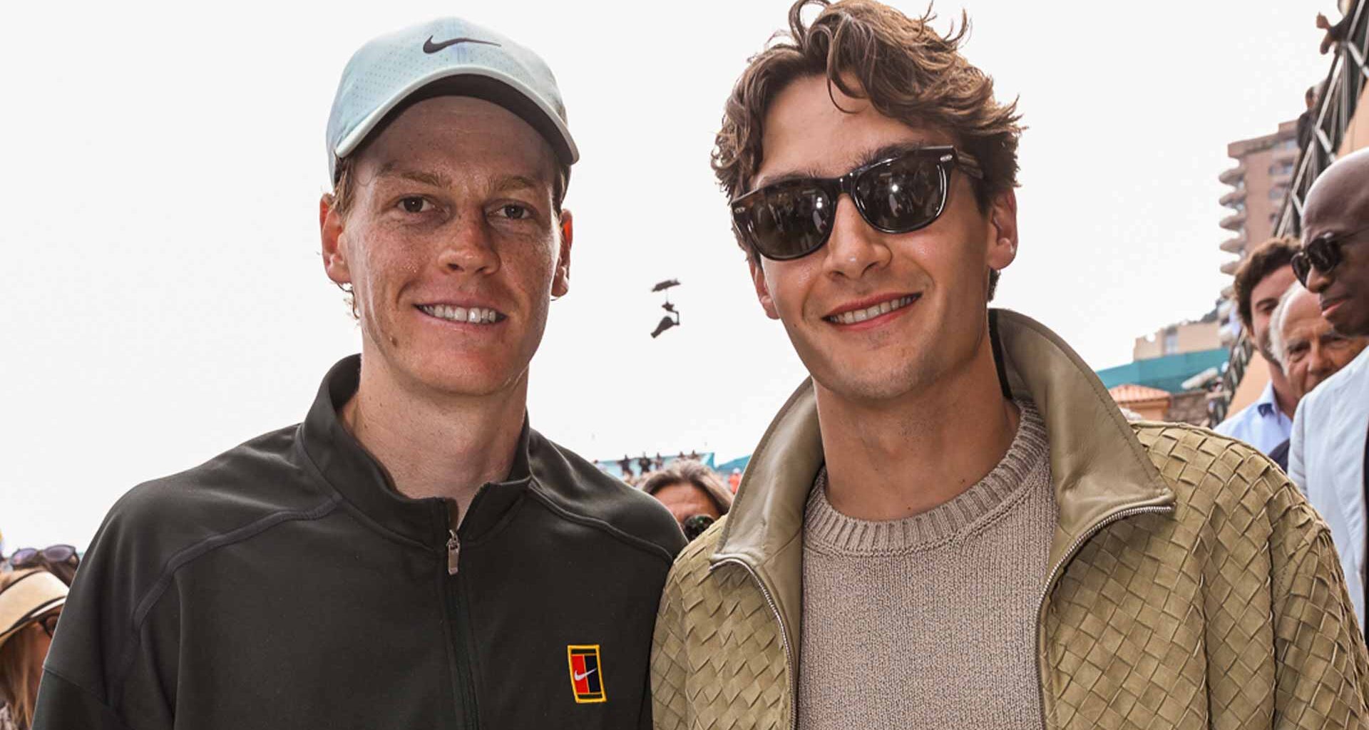 Jannik Sinner and George Russell pose for a photo after Sinner's quarter-final win in Monte-Carlo Friday.