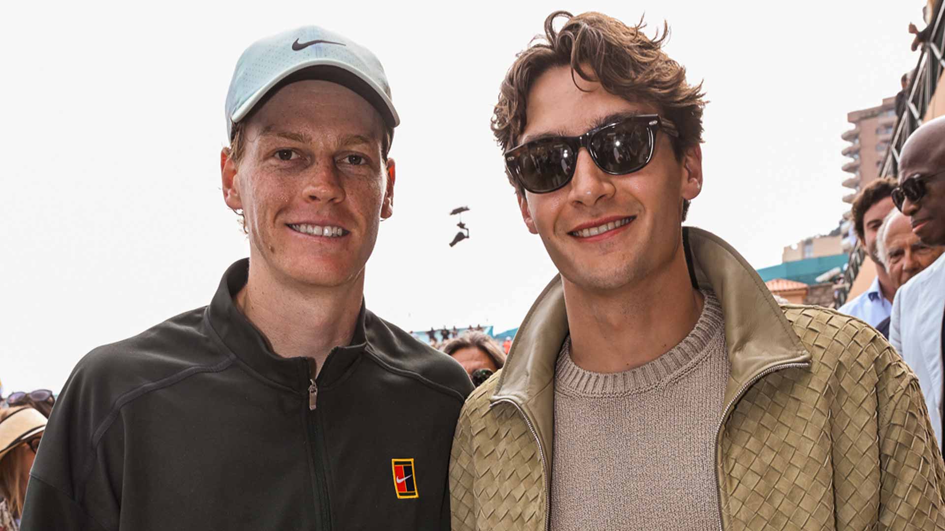 Jannik Sinner and George Russell pose for a photo after Sinner's quarter-final win in Monte-Carlo Friday.