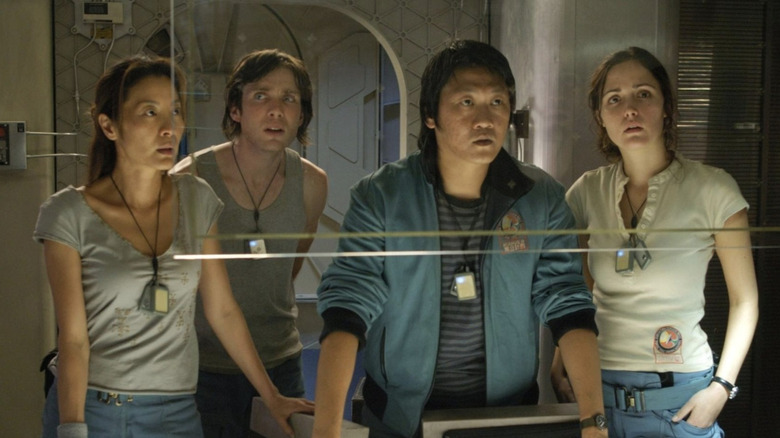 Michelle Yeoh as Corazon, Cillian Murphy as Robert Capa, Benedict Wong as Trey, Rose Byrne as Cassie standing together and looking at the ship's information in Sunshine