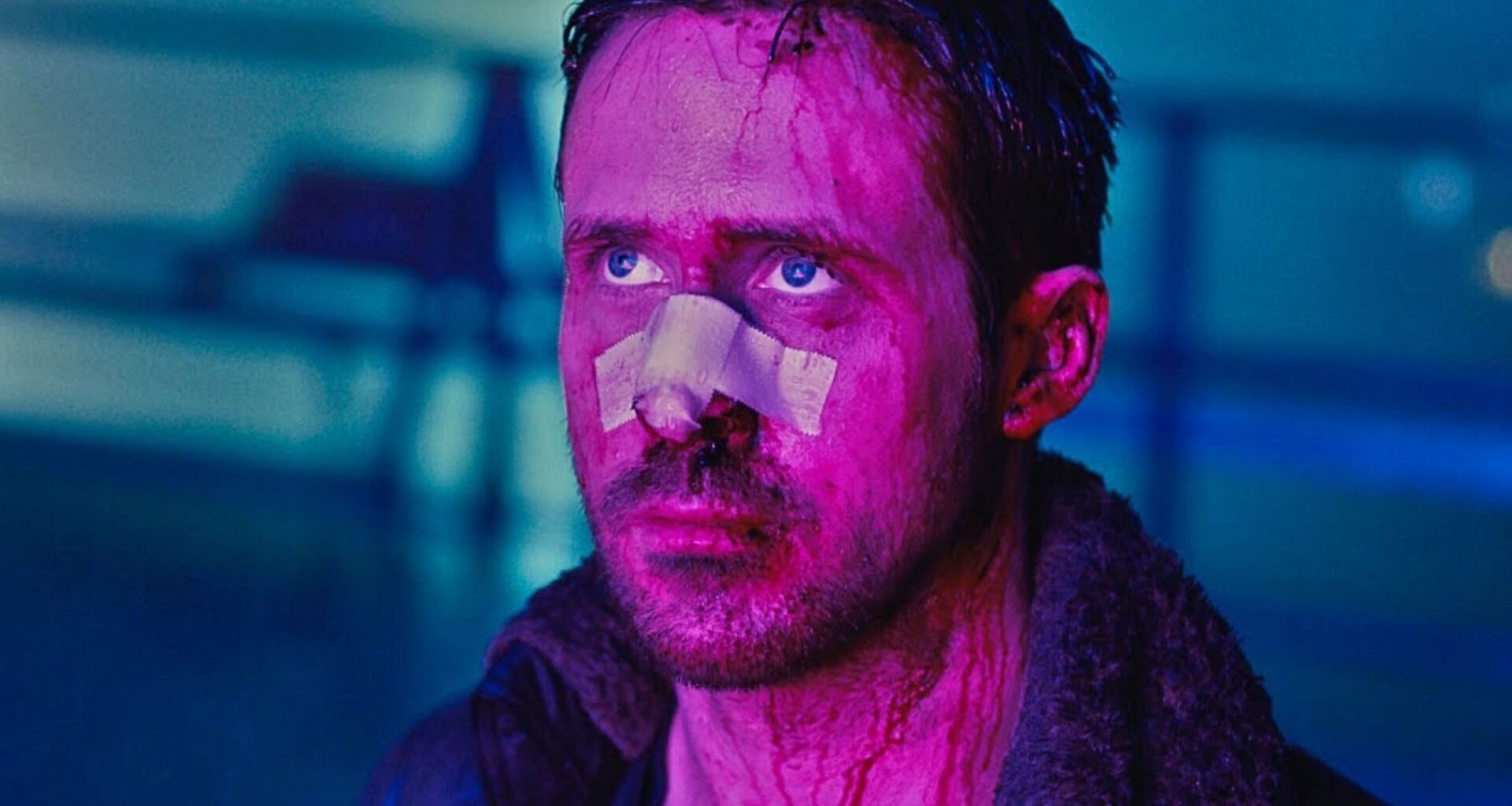 Ryan Gosling looking worse for wear looking up lit by purple light