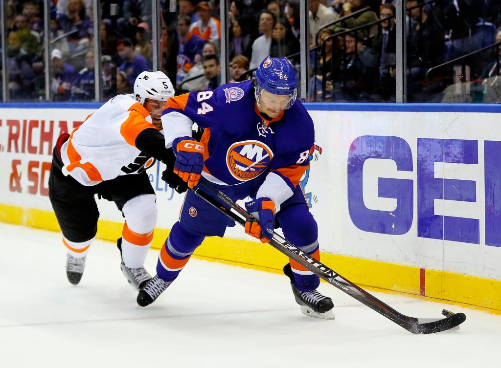 Philadelphia Flyers player Braydon Coburn checks New York Islanders player Mikhail Grabovski during an NHL hockey game.