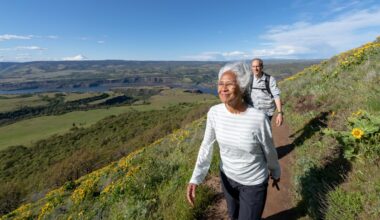 Two people outside walking on a trail.