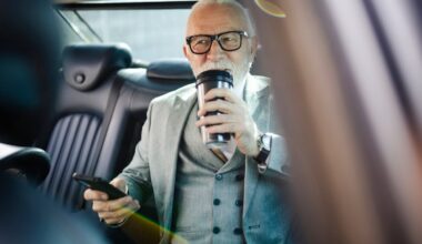 An older person in a car drinking.