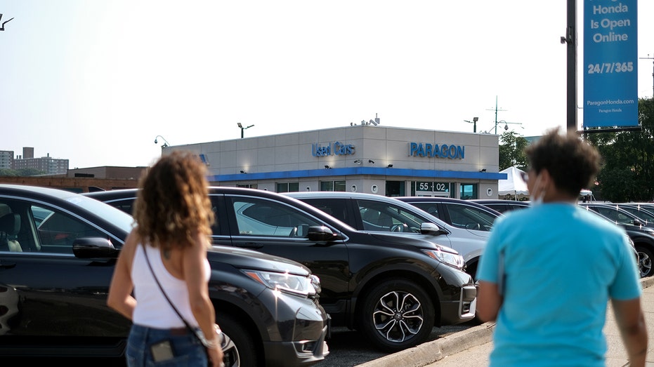 Pedestrians at a dealership in the Queens borough of New York.