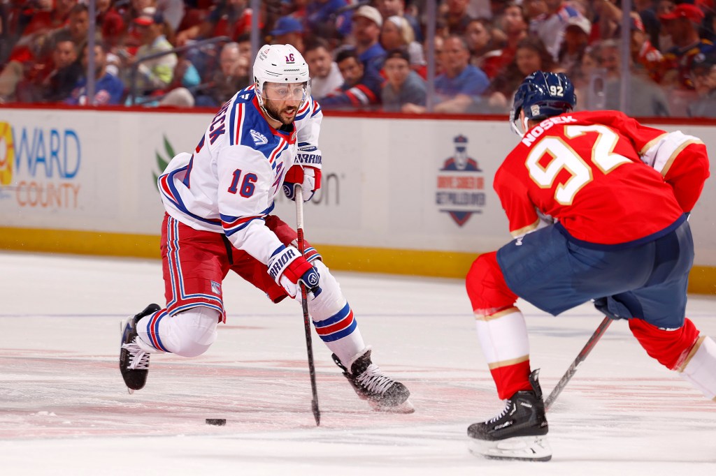 New York Rangers player Vincent Trocheck skates with the puck, facing Florida Panthers player Tomas Nosek.