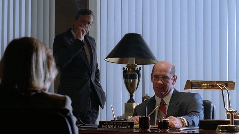 Skinner talks with Scully as the Cigarette Smoking Man looks on