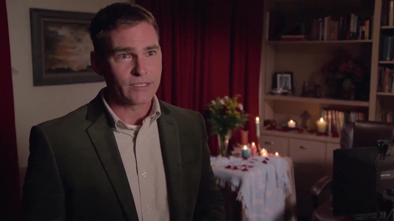 Father Joe Binghoffer (Seann William Scott) speaks to the camera by a romantically arranged table in Welcome to Flatch