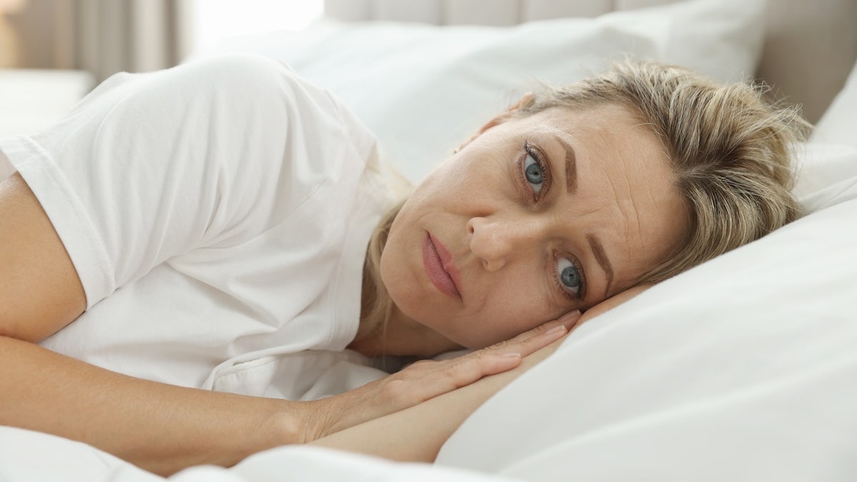 Woman awake in bed suffering from insomnia indoors