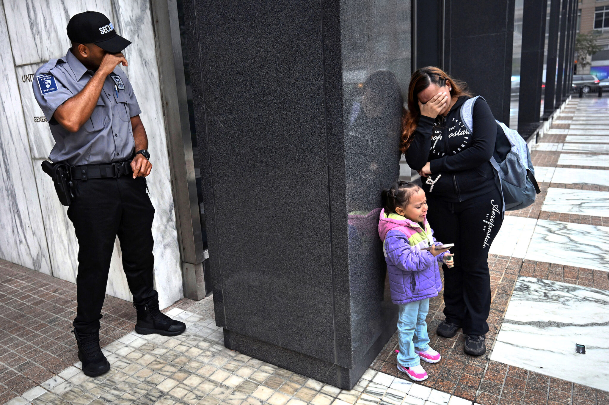 Carol Guzy, “ICE Arrests at New York Court,“ for the Miami Herald. A security guard breaks down while witnessing a family separation. Security personnel frequently find themselves caught between federal agents, desperate families, and protesters in the increasingly volatile courthouse environment. New York, N.Y., August 20, 2025.