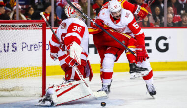 Dec 10, 2025; Calgary, Alberta, CAN; Detroit Red Wings defenseman Travis Hamonic (52) and Calgary Flames right wing Matt Coronato (27) fight for position in front of Detroit Red Wings goaltender John Gibson (36) during the second period at Scotiabank Saddledome. Mandatory Credit: Sergei Belski-Imagn Images
