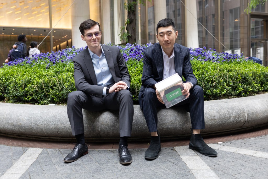 Recyclers Liam Bernie and Hyung Mo Chun hold a vape collection box while sitting for a portrait outside Grand Central.