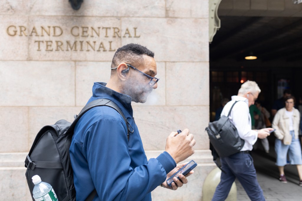 A commuter vapes outside Grand Central Terminal,