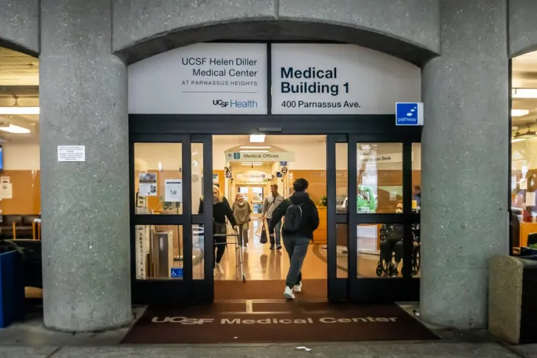 Entrance to UCSF Medical Center’s Medical Building 1 at 400 Parnassus Ave, with people entering and exiting through glass doors.